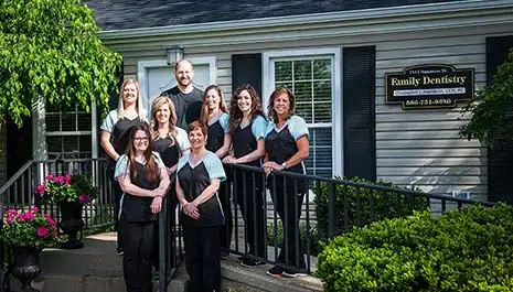 our dental team standing in front of the office sign.